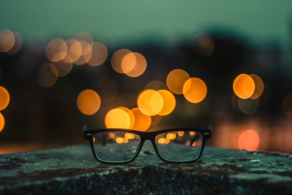 Brille vor unscharfen Lichtern &ndash; verschwommenes Sehen