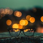 Brille vor unscharfen Lichtern &ndash; verschwommenes Sehen