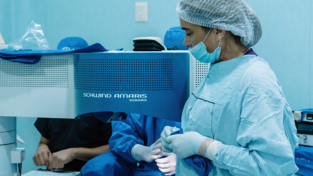 Chirurg neben einem Excimer-Laser während einer Augenlaser-Operation (LASIK)