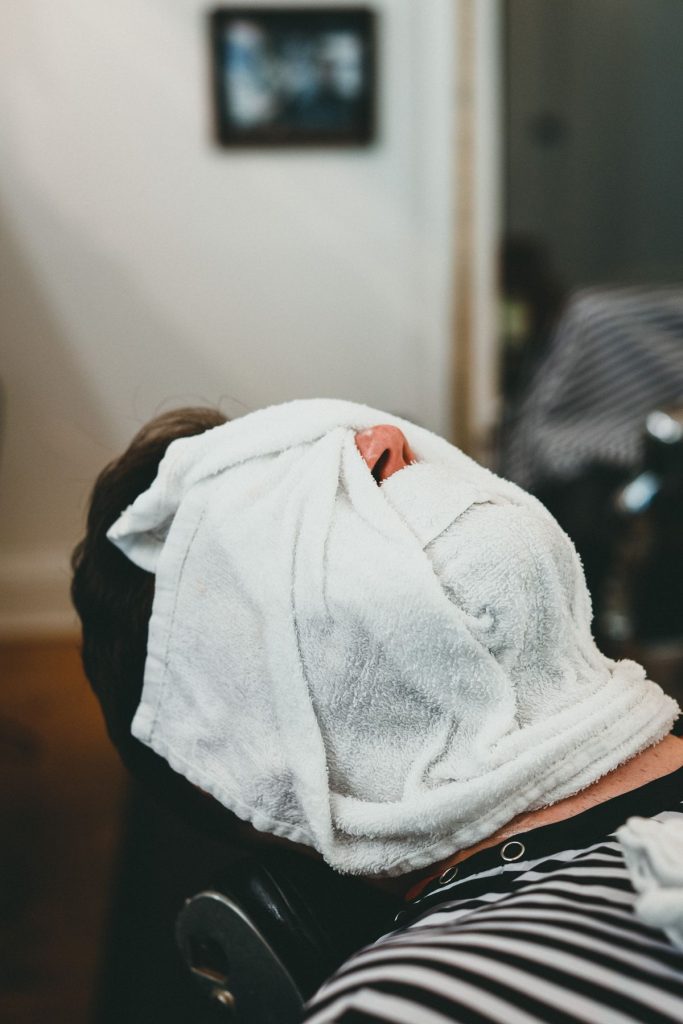 Person relaxing with a warm compress for dry eye